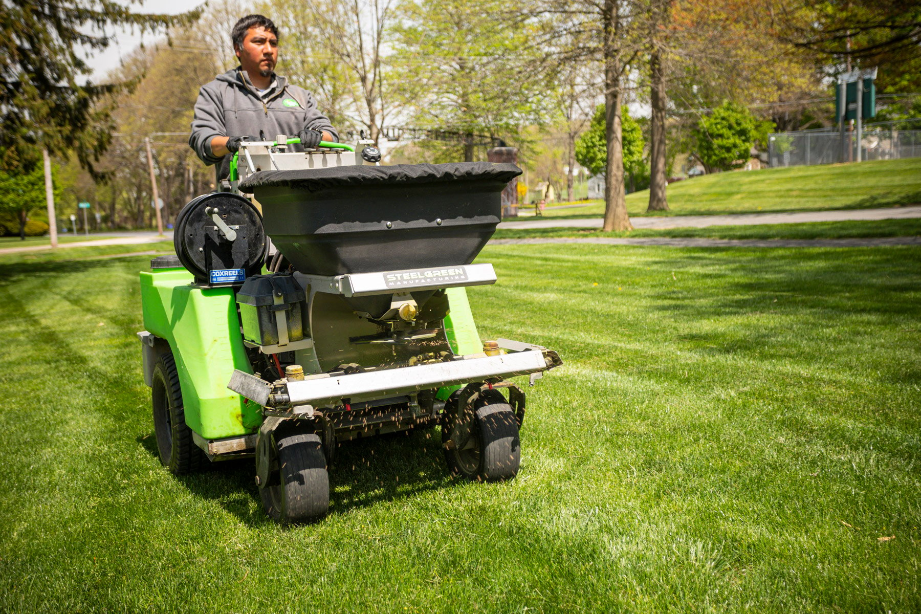 Commercial lawn care technician spreading limestone