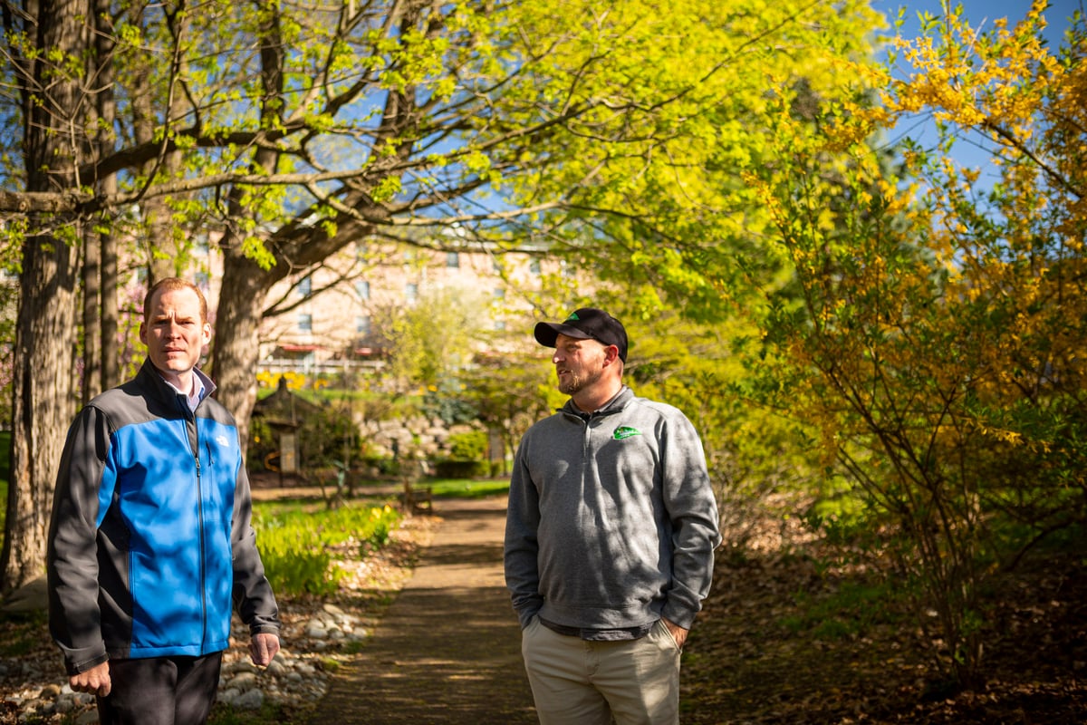 homeowner inspects trees with technician 