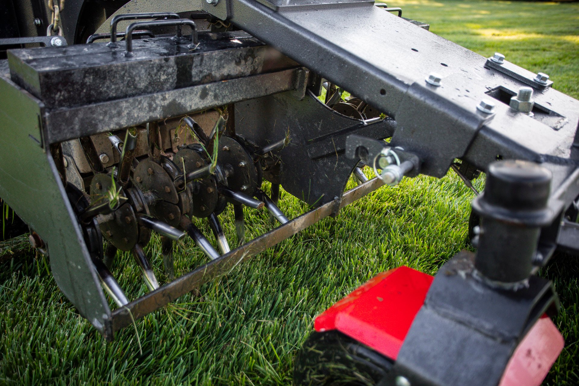 lawn aeration machine pulling plugs of soil out of a lawn