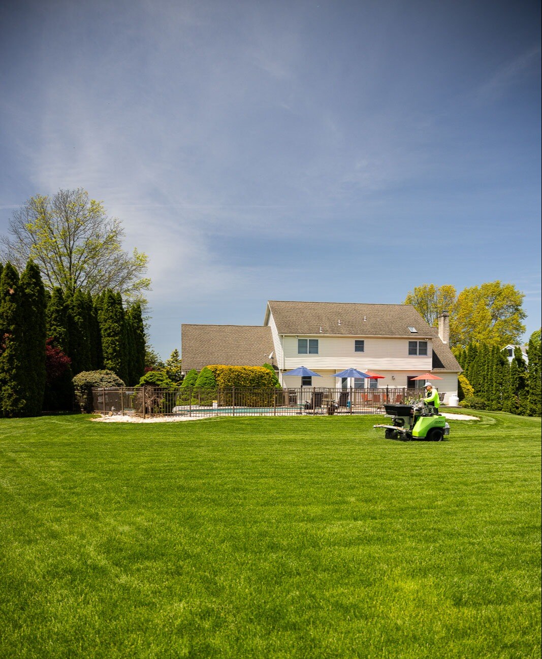 lawn care technician operating lawn spreader in backyard 6 lawn care technician operating lawn spreader in backyard 6