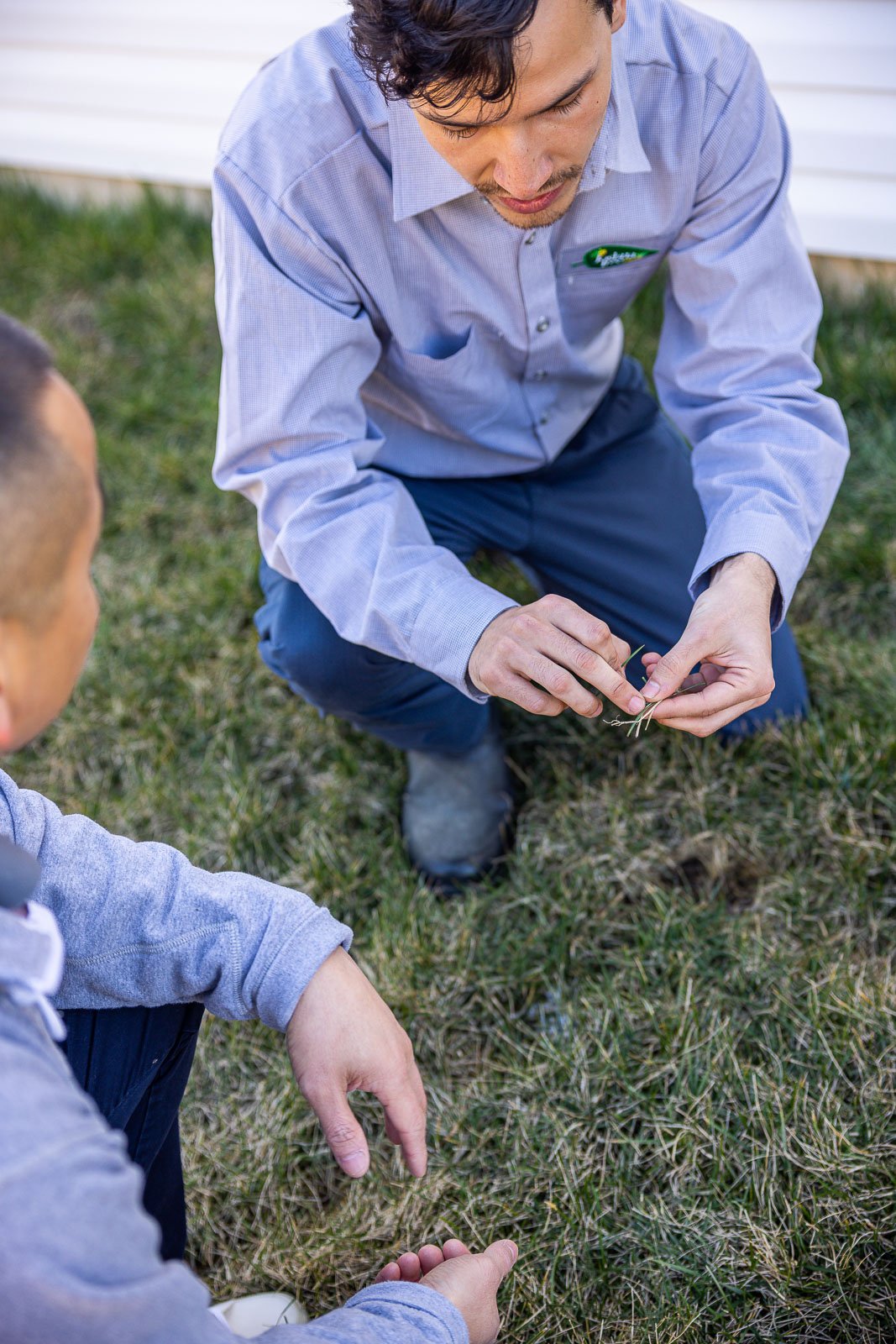 lawn care technician and customer reviewing a lawn area