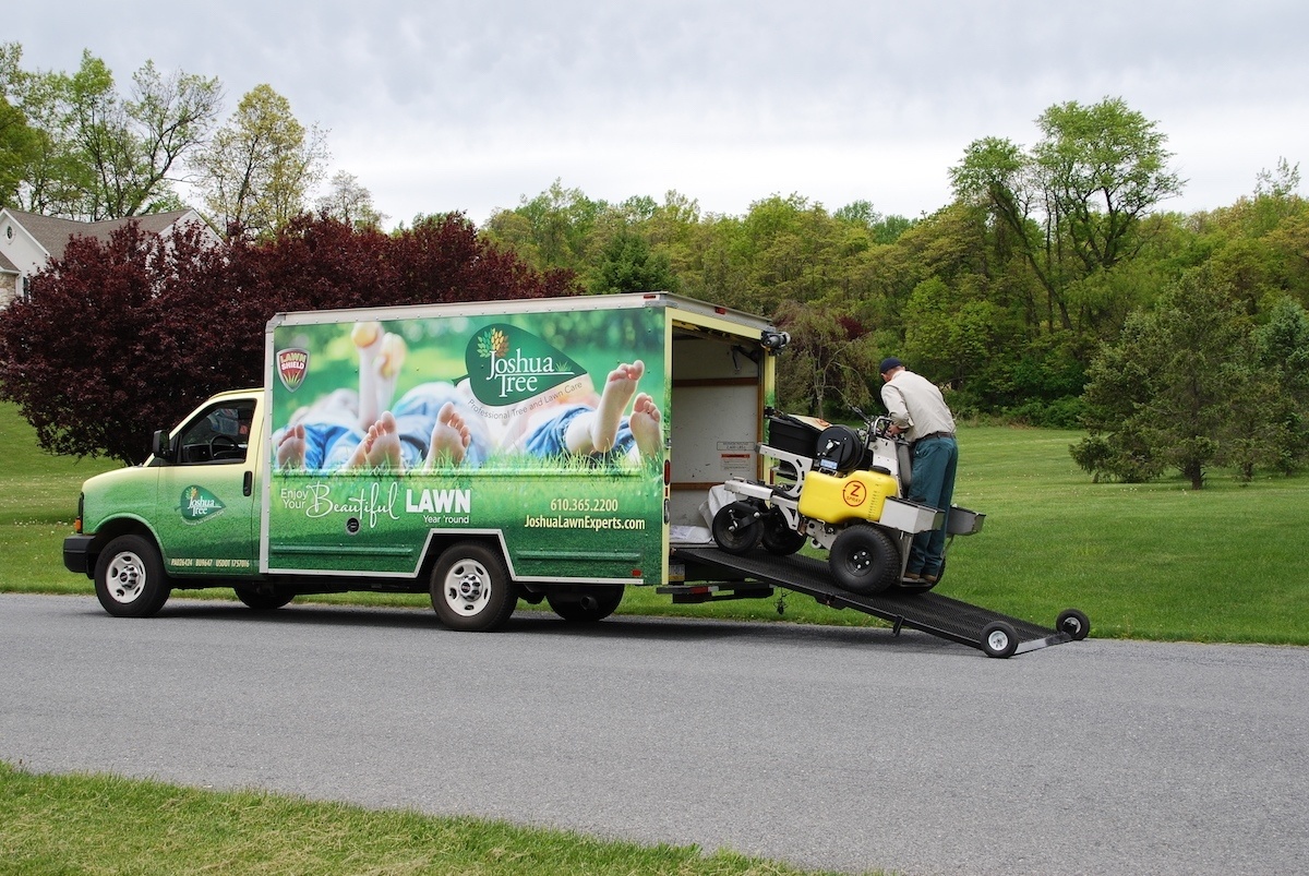 lawn care technician unloads fertilizer from box truck
