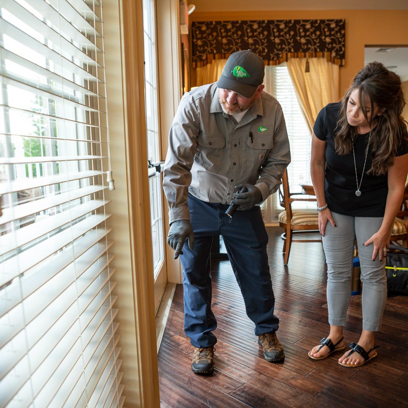 pest control expert shows customer problem area in home