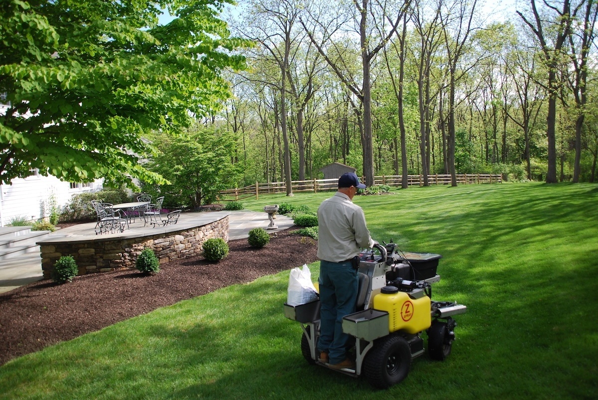 Lawn care technician fertilizing a customers lawn