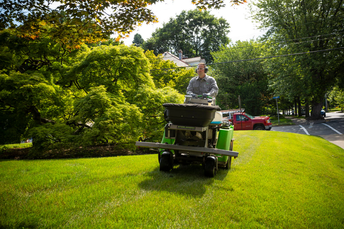 Lawn care technician applying fertilizer