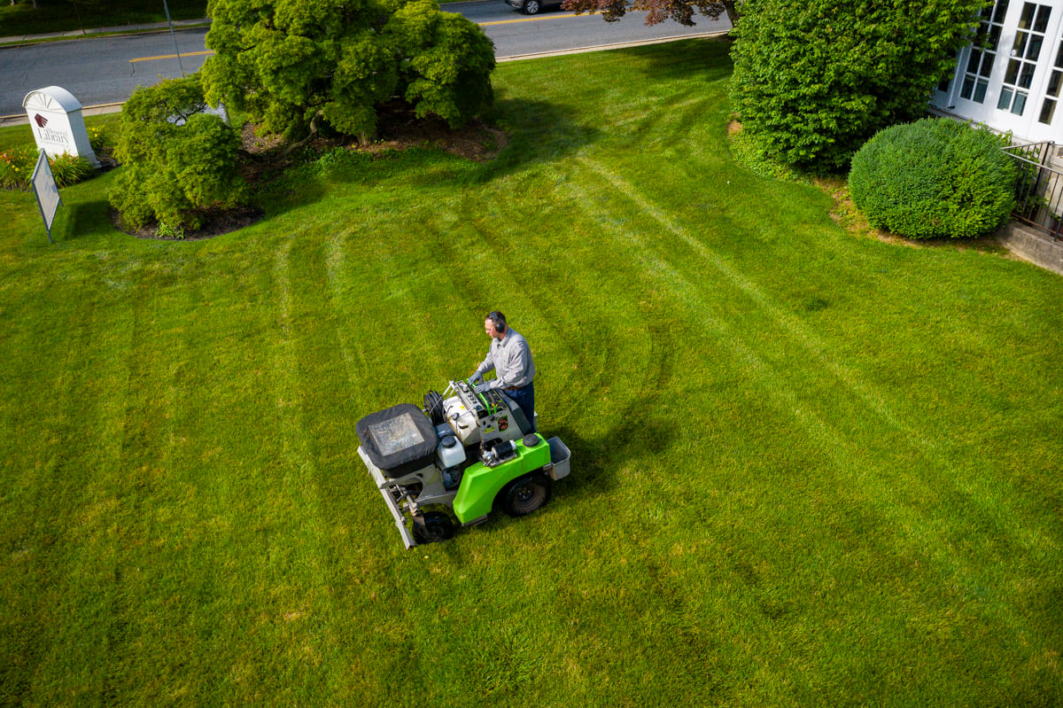 commercial lawn care technician applying fertilizer