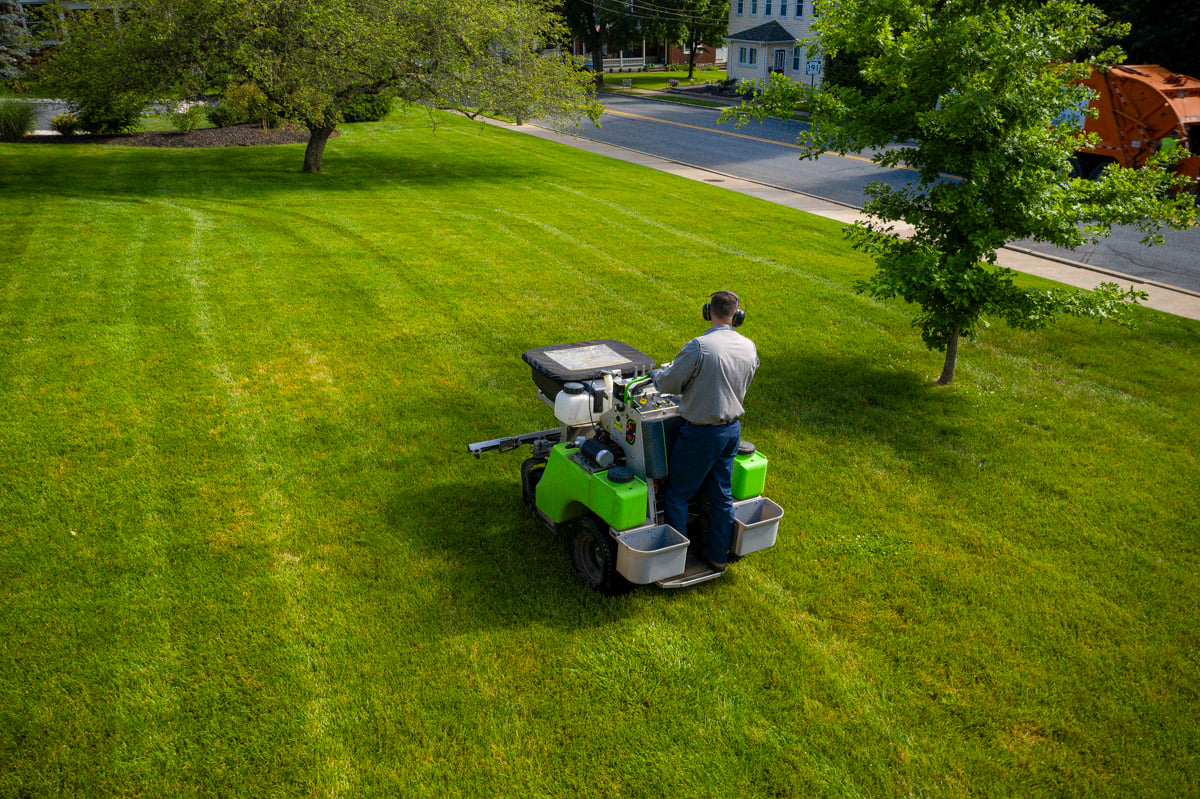 Lawn care technician fertilizing