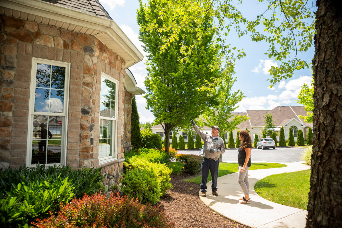 pest control technician and customer inspecting outdoor areas for pests