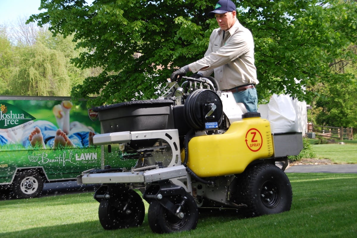 lawn care technician applying fertilizer